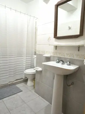 a bathroom with a sink and a toilet and a mirror at Hostería Champaquí in Los Hornillos