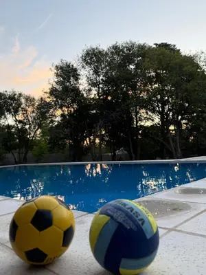 two soccer balls sitting on the ground next to a pool at Hostería Champaquí in Los Hornillos