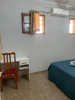 a bedroom with a bed and a desk and a chair at Habitación Individual in Cordoba