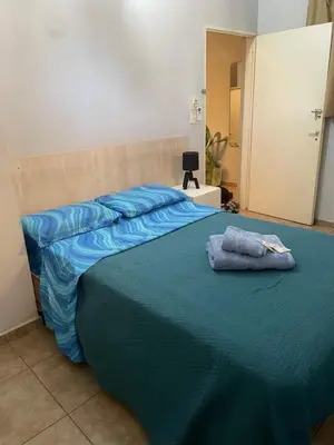 a large bed with blue sheets and pillows on it at Habitación Individual in Cordoba