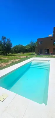 a large blue swimming pool in front of a building at Casa Privada Los Cardenales in Nono