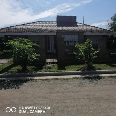 a brick house with trees in front of it at La Linda in Villa Carlos Paz