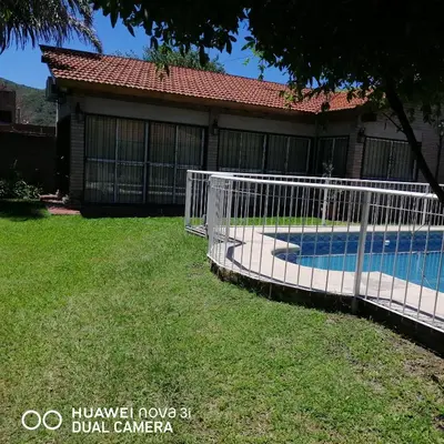 a white fence in front of a house at La Linda in Villa Carlos Paz