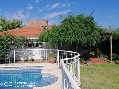 a white fence around a swimming pool in a yard at La Linda in Villa Carlos Paz