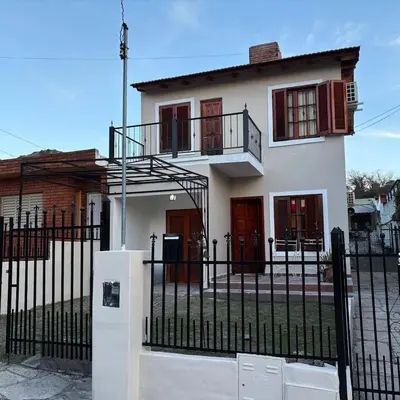 a white house with a black fence at Casa Expectacular cerca de la montaña in Villa Carlos Paz