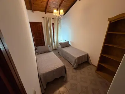 a room with two beds and a book shelf at Casa Expectacular cerca de la montaña in Villa Carlos Paz