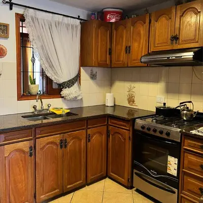 a kitchen with wooden cabinets and a stove top oven at Casa Expectacular cerca de la montaña in Villa Carlos Paz