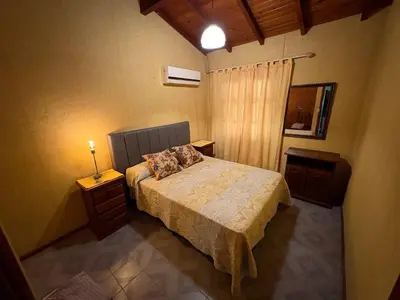 a bedroom with a bed and a lamp on a table at Casa Expectacular cerca de la montaña in Villa Carlos Paz