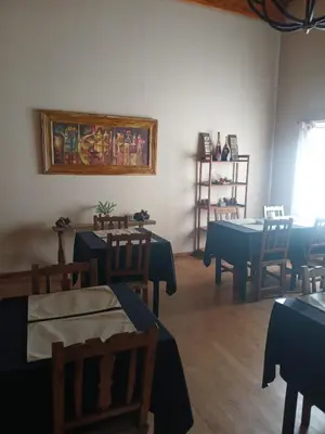 a dining room with tables and chairs and a painting on the wall at Posada Vientos de Belgrano in Villa General Belgrano