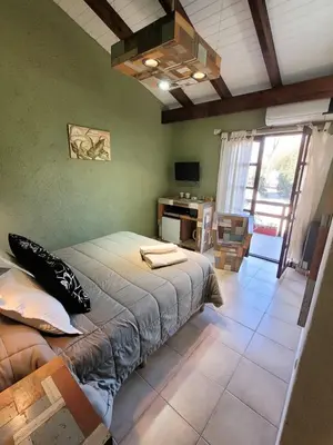 a bedroom with a bed and a desk in it at Posada Vientos de Belgrano in Villa General Belgrano