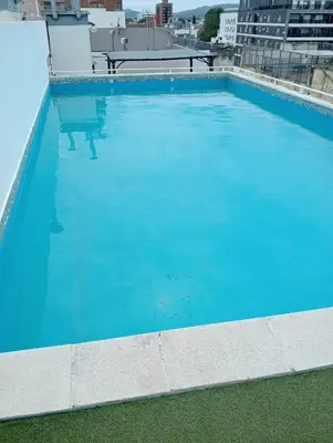 a large blue swimming pool on top of a building at Nenu Villa Carlos Paz Departamento Céntrico piscina in Villa Carlos Paz