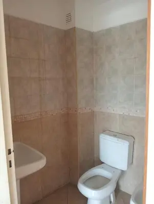 a bathroom with a toilet and a tub and a sink at Nenu Villa Carlos Paz Departamento Céntrico piscina in Villa Carlos Paz