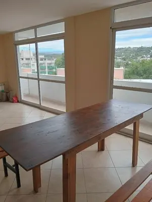 a wooden bench in a room with a large window at Nenu Villa Carlos Paz Departamento Céntrico piscina in Villa Carlos Paz