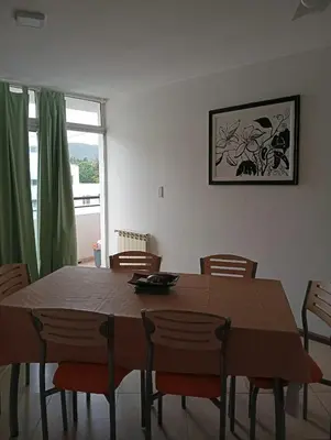 a dining room with a wooden table and chairs at Nenu Villa Carlos Paz Departamento Céntrico piscina in Villa Carlos Paz