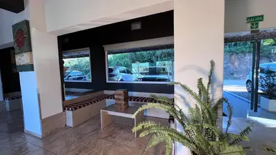a room with a bench and a plant in a building at Hotel y Cabañas Capri in Villa Carlos Paz