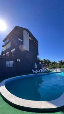 a large swimming pool in front of a building at Hotel y Cabañas Capri in Villa Carlos Paz