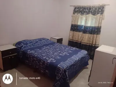 a small bedroom with a bed and a curtain at El Descanso in Nono