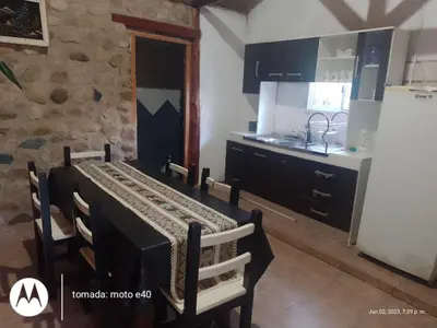 a kitchen with a table and chairs in a room at El Descanso in Nono