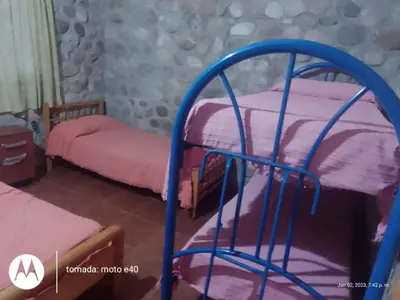 a room with two bunk beds with pink sheets at El Descanso in Nono