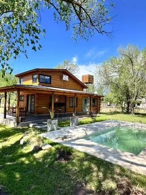 a log house with a pool in front of it at Cabaña para 6 personas en Calamuchita - Córdoba - 