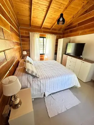 a bedroom with a bed and a flat screen tv at Cabaña para 6 personas en Calamuchita - Córdoba - 