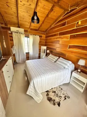 a bedroom with a bed and a wooden wall at Cabaña para 6 personas en Calamuchita - Córdoba - 