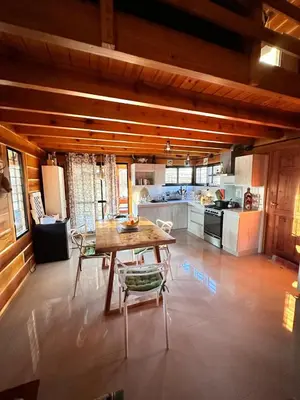 a large kitchen with a wooden table and chairs at Cabaña para 6 personas en Calamuchita - Córdoba - 