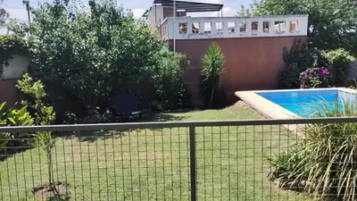 a fence in front of a yard with a swimming pool at Samay in Villa Carlos Paz