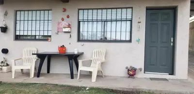 a table and two chairs sitting next to a house at Samay in Villa Carlos Paz