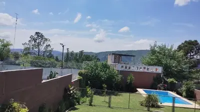a house with a swimming pool and a fence at Samay in Villa Carlos Paz