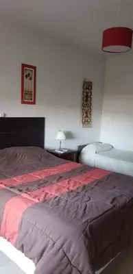 a bedroom with a large bed with a red blanket at Samay in Villa Carlos Paz