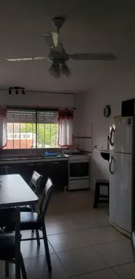 a kitchen with a refrigerator and a table and chairs at Samay in Villa Carlos Paz