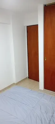 an empty room with a bed and a wooden door at Depto 1 Dorm Excelente Ubicacion Alta Cordoba Iluminado in Cordoba