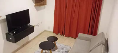 a living room with a television and a chair at Depto 1 Dorm Excelente Ubicacion Alta Cordoba Iluminado in Cordoba