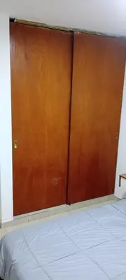 a large wooden door in a room with a bed at Depto 1 Dorm Excelente Ubicacion Alta Cordoba Iluminado in Cordoba