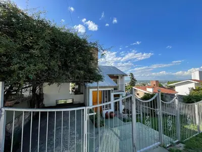 a white fence in front of a house at Casa de Alvita in Villa Carlos Paz