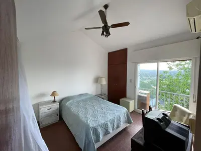 a bedroom with a bed and a ceiling fan at Casa de Alvita in Villa Carlos Paz