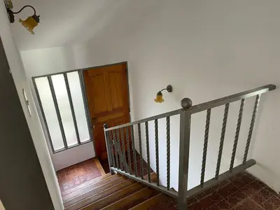 a hallway with a staircase with a wooden door at Casa de Alvita in Villa Carlos Paz
