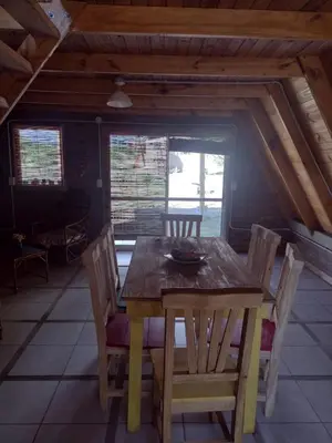 a wooden table and chairs in a room at Complejo Ayün in Travesía