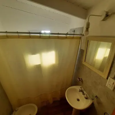 a bathroom with a sink and a toilet and a mirror at Complejo Ayün in Travesía