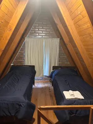 a attic bedroom with two beds and a window at Complejo Ayün in Travesía