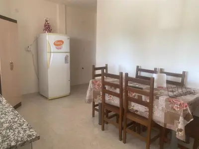 a dining room with a table and a white refrigerator at Depart in Embalse