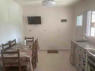 a dining room with a table and a tv on the wall at Depart in Embalse