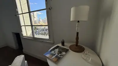 a lamp on a table in a room with a window at Home lab studio in Cordoba