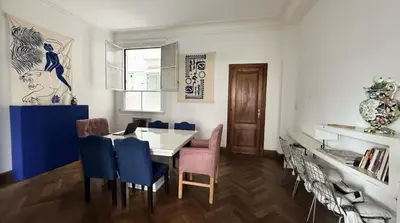 a dining room with a table and blue chairs at Home lab studio in Cordoba