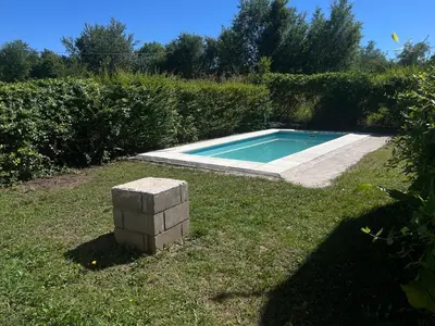 a swimming pool in the grass with a brick pillar at Timtaya in Barrio Parque El Corcovado
