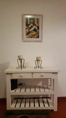 a white console table with two vases on top at Urban 360 in Río Cuarto