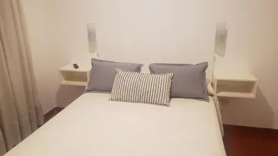 a white bed with two pillows on top of it at Urban 360 in Río Cuarto