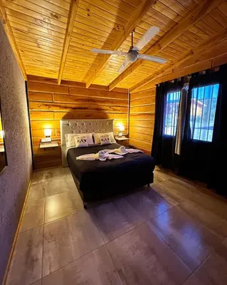 a bedroom with a bed in a wooden room at Terrazas del Algarrobo in Santa Rosa de Calamuchita