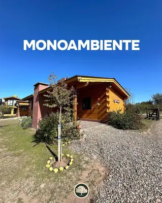 a small tree in front of a log cabin at Terrazas del Algarrobo in Santa Rosa de Calamuchita